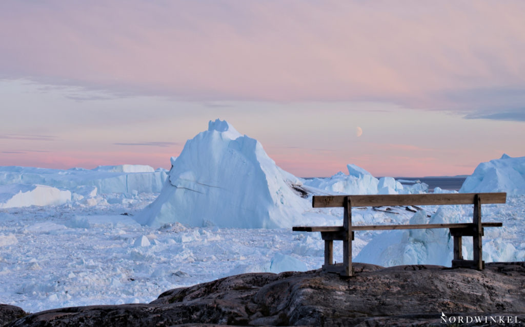 Bank über dem Eisfjord in Ilulissat zum Sonnenuntergang