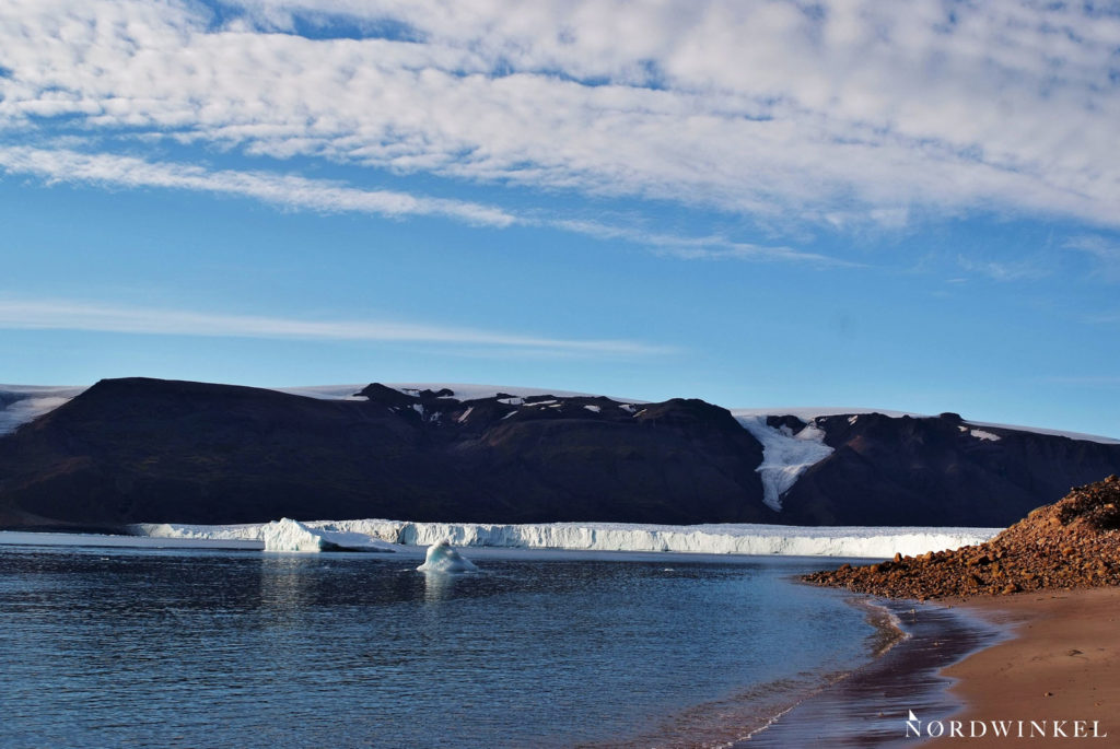 gletscherfront im moris-jesup-fjord mit einzelnen eisbrocken im wasser