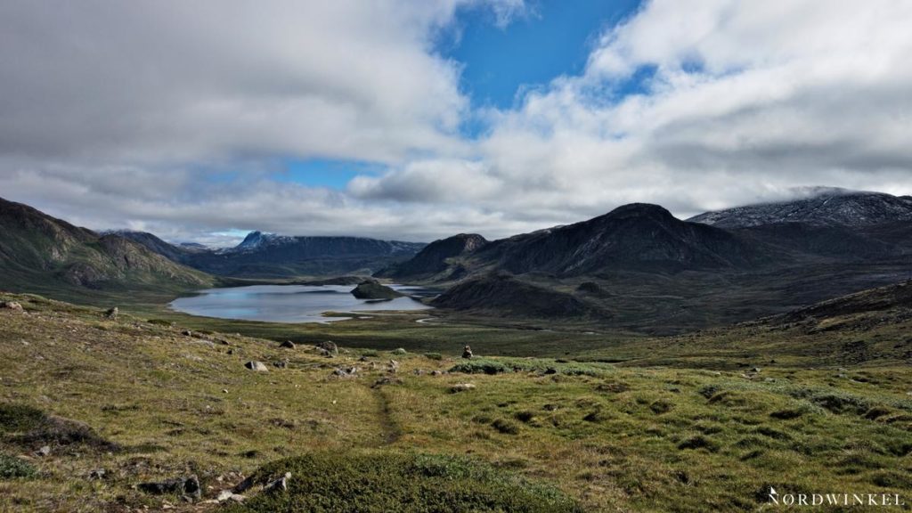 arktische Tundra unter bedecktem himmel mit einem see