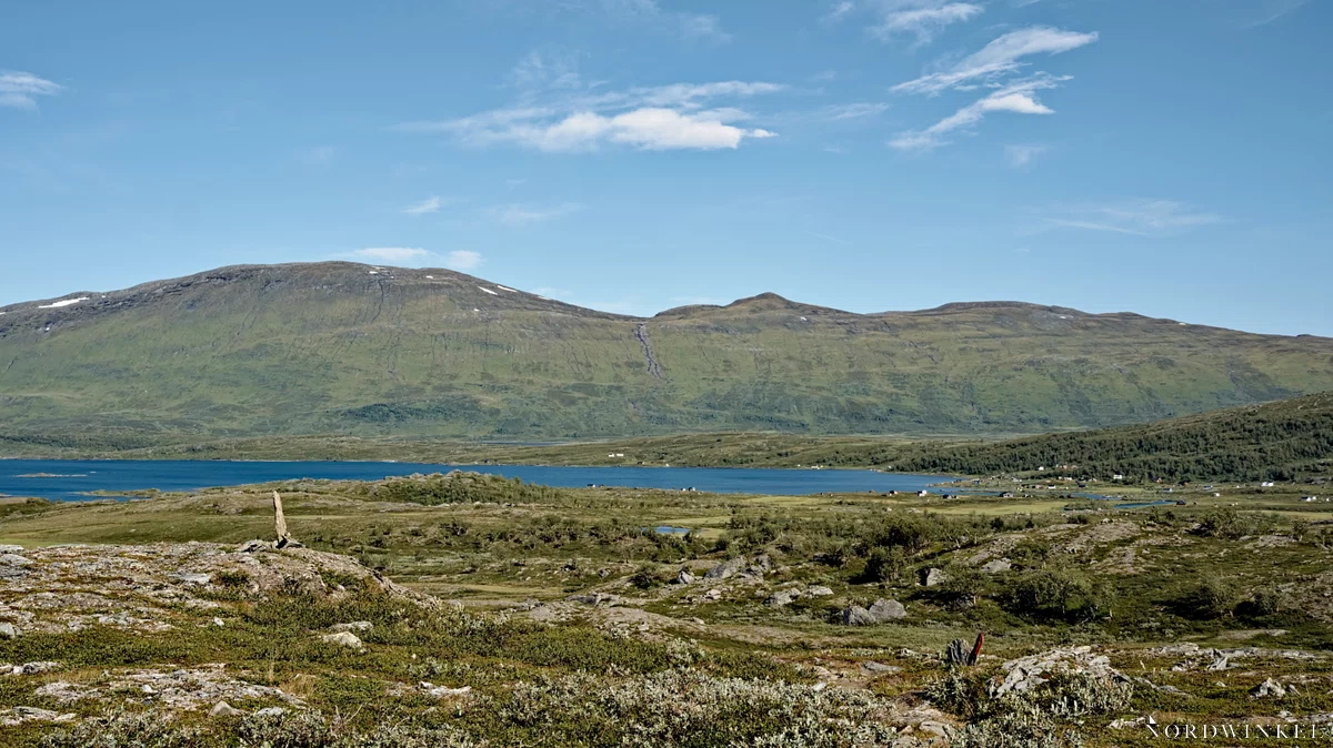 sami-siedlung in karger landschaft an einem seeufer